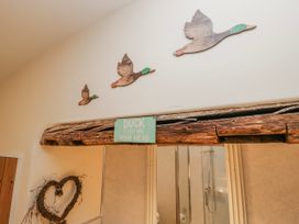 A hallway with wooden ducks on the wall at High Ickenthwaite Farmhouse in Ulverston