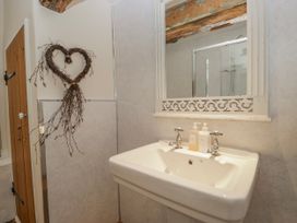 A sink with a mirror and toiletries at High Ickenthwaite Farmhouse Ulverston