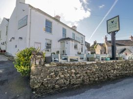 An outdoor view of the Manor House showing tables and chairs at High Ickenthwaite Farmhouse Ulverston