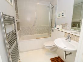 A bathroom with a bathtub shower combination toilet sink and heated towel rail at Plimoth N8 in Yarmouth