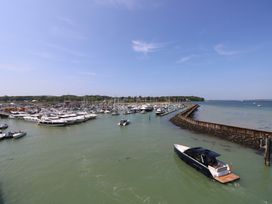 A marina with several boats docked and a boat moving in the water at Plimoth N8 in Yarmouth