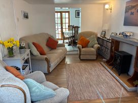 A living room with a sofa, armchair, and fireplace at Coedmor, Newport, Pembrokeshire