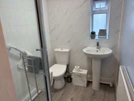 A bathroom featuring a shower, toilet, sink, and towel rack at Coedmor in Newport, Pembrokeshire