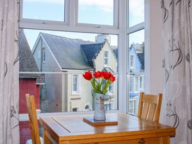 A dining room with a table and vase of tulips at 2 The Elms in Salcombe
