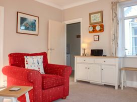 A living room with an armchair and console table at 2 The Elms Salcombe