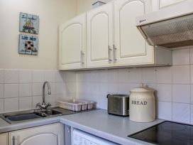 A kitchen with a sink and kitchen cabinet at 2 The Elms in Salcombe