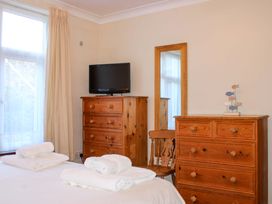 A bedroom with a television and dressers at 2 The Elms in Salcombe