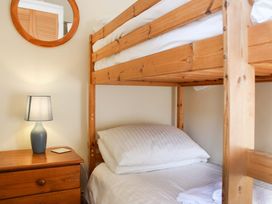 A bedroom with a bunk bed and a lamp at 2 The Elms in Salcombe