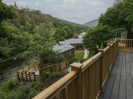 A view of cabins and a river surrounded by trees at Hodge Luxury Pod Keswick