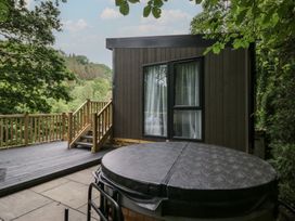 An outdoor area with a hot tub and decking at Hodge Luxury Pod in Keswick