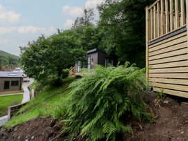 An outdoor area with a pod, decking, and greenery at Hodge Luxury Pod in Keswick