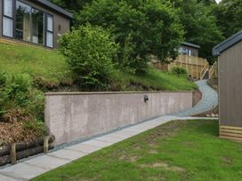 An outdoor area with a pathway leading to lodges with greenery at Hodge Luxury Pod in Keswick