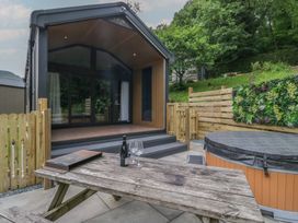 An outdoor area with a pod and hot tub at Dubs Luxury Family Pod in Keswick