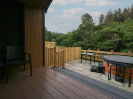 An outdoor area with a hot tub and table at Woof Luxury Family Pod in Keswick
