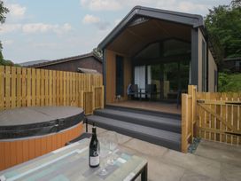 An outdoor area with a hot tub and seating at Woof Luxury Family Pod in Keswick