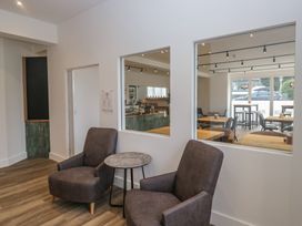 A cafe seating area with armchairs and a side table at Woof Luxury Family Pod in Keswick