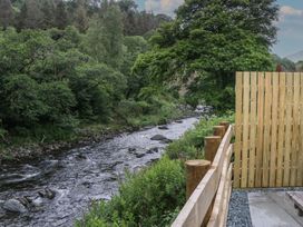 A view of a river with rocks and greenery at Sail Luxury Family Pod Keswick