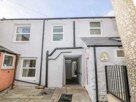An outdoor area with a building, windows, and a clock at Hocking Cottage in St Marychurch