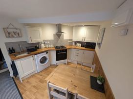 A kitchen with appliances and dining table at Hocking Cottage in St Marychurch