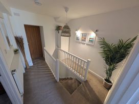 A hallway with a staircase and wall pictures at Hocking Cottage St Marychurch