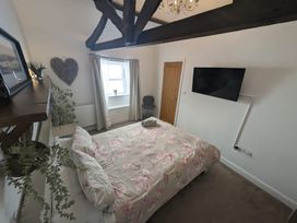 A bedroom with a bed and television at Hocking Cottage St Marychurch