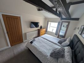 A bedroom with a bed and television at Hocking Cottage St Marychurch