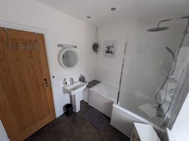 A bathroom with a bath and sink at Hocking Cottage St Marychurch