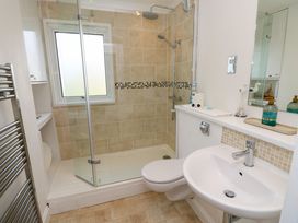 A bathroom with a walk-in shower a toilet a sink a mirror and a towel radiator at Plimoth N9 in Yarmouth