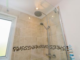A tiled shower area with a rain shower head and handheld shower at Plimoth N9 in Yarmouth
