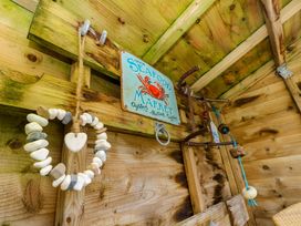 A wooden wall with a seafood market sign a heart shaped stone garland and hanging nautical decorations at Plimoth N9 in Yarmouth