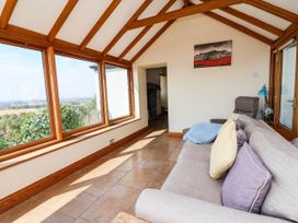 A conservatory with windows and a sofa at Ael Y Bryn Dyserth