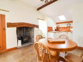 A dining room with a table and chairs at Ael Y Bryn Dyserth