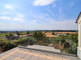 An outdoor view showing a patio and surrounding fields at Ael Y Bryn Dyserth