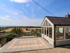 A conservatory with glass windows overlooking the landscape at Ael Y Bryn Dyserth