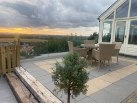 An outdoor patio with a table and chairs at Ael Y Bryn in Dyserth