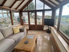 A conservatory with a sofa and television at Ael Y Bryn Dyserth