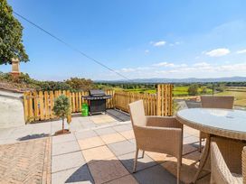 An outdoor area with a barbecue grill and seating at Ael Y Bryn in Dyserth