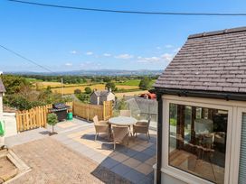 A patio area with a table and chairs at Ael Y Bryn Dyserth