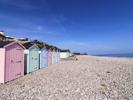 A row of beach huts along a pebbled beach at Badger's Den Budleigh Salterton
