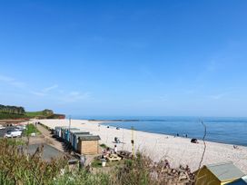 A beach with huts and people at Badger's Den Budleigh Salterton