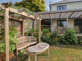 A garden with a bench and table under a pergola at Torestin in Kilmington