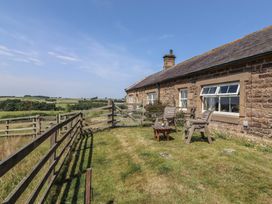 A wooden house with chairs and a table in the garden at Folly View Eglingham