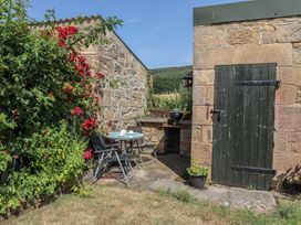 A garden with a table and chairs at Folly View in Eglingham