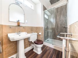 A bathroom with a pedestal sink toilet and glass shower enclosure at Fir Trees in Windermere