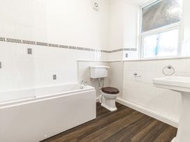 A bathroom with a bathtub toilet and sink and a window at Fir Trees in Windermere