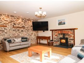 A living room with a sofa and fireplace at Higher Weekaborough Farm near Ipplepen