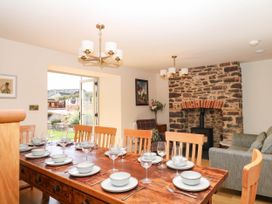 A dining room with a wooden table and chairs at Higher Weekaborough Farm in Coombe Fishacre near Ipplepen