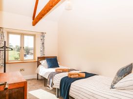 A bedroom with two beds and a window at Higher Weekaborough Farm in Coombe Fishacre near Ipplepen