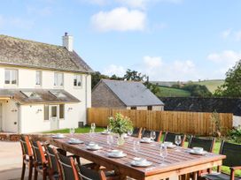 An outdoor dining setup with a table and chairs at Higher Weekaborough Farm Coombe Fishacre near Ipplepen