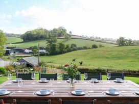 An outdoor dining area with a table set for meals at Higher Weekaborough Farm near Coombe Fishacre Ipplepen